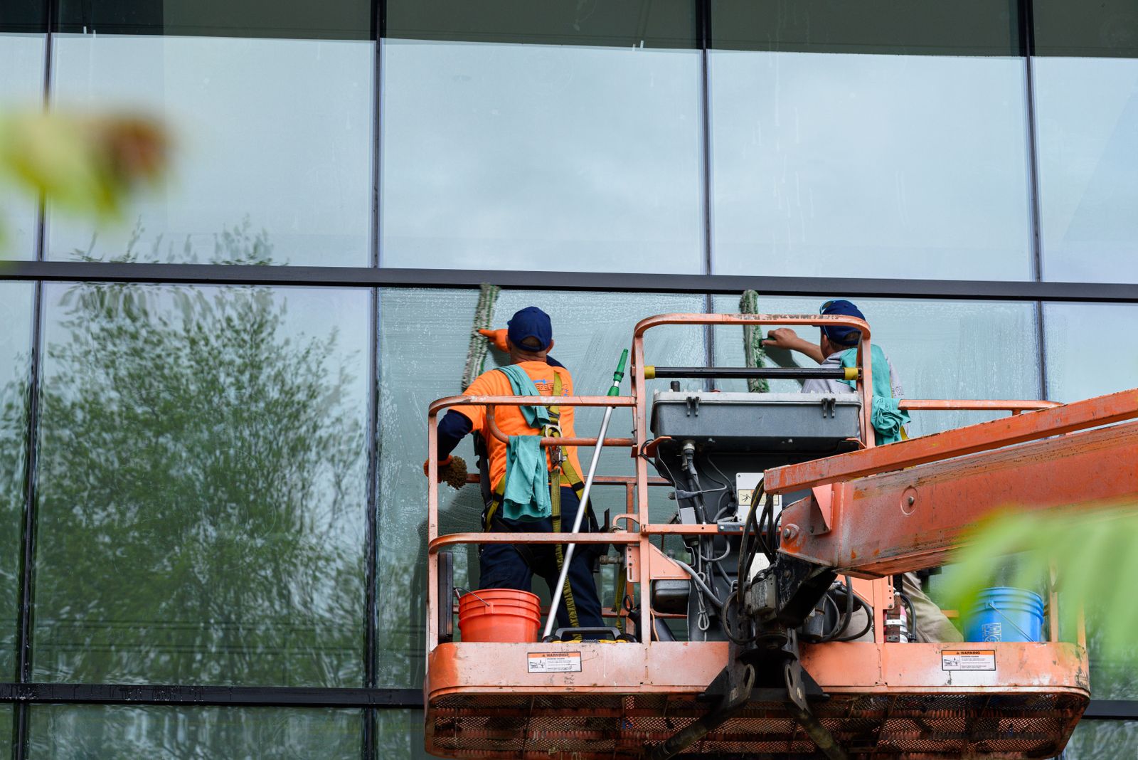 Professionelle Fensterreiniger an einer Glasfassade